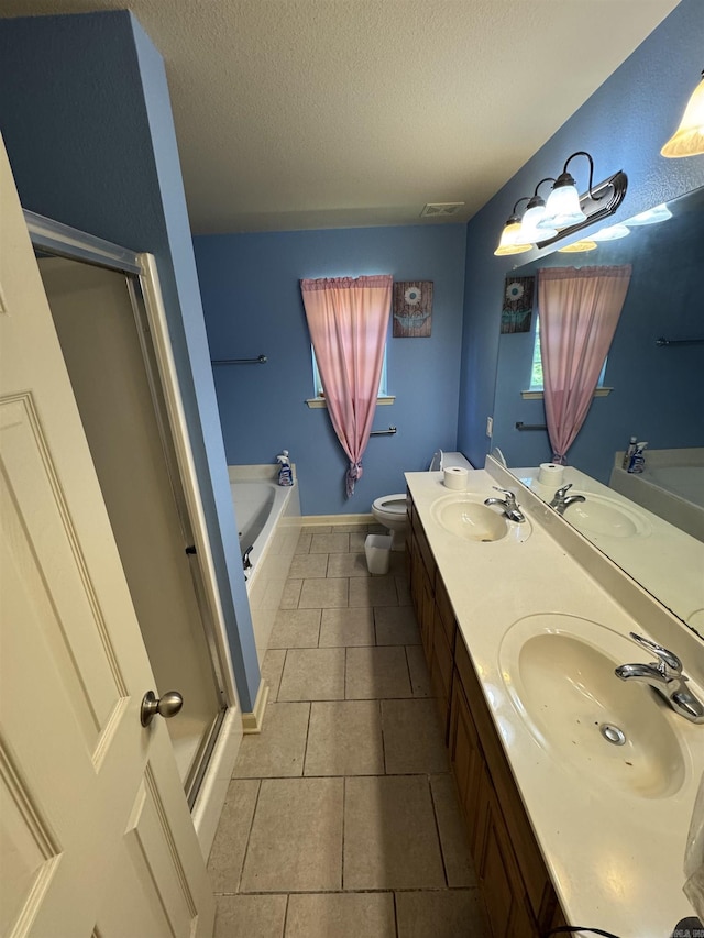 bathroom featuring a garden tub, a textured ceiling, a shower stall, double vanity, and tile patterned flooring