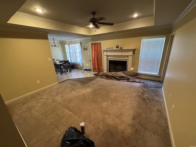 unfurnished living room with ornamental molding, a raised ceiling, a ceiling fan, a fireplace, and recessed lighting