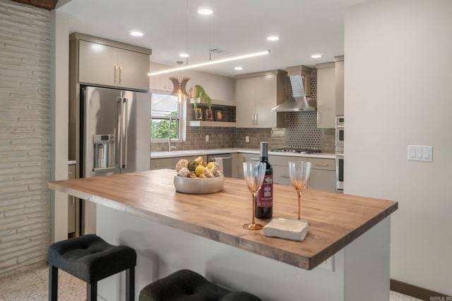 128 Dickson Dr, Little Rock, AR 72207 - kitchen featuring wooden counters, wall chimney exhaust hood, backsplash, and a kitchen breakfast bar