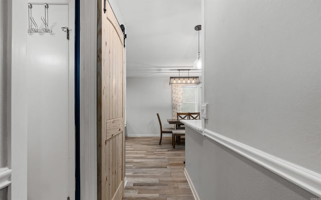 9 San Vincente Pl, Hot Springs Village, AR 71909 - corridor featuring a barn door and light wood-type flooring