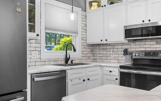 9 San Vincente Pl, Hot Springs Village, AR 71909 - kitchen featuring appliances with stainless steel finishes, decorative backsplash, white cabinetry, and pendant lighting