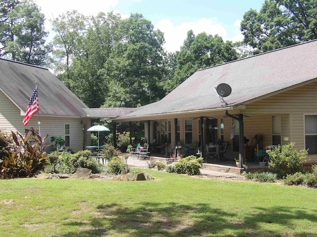 rear view of property featuring a patio area and a yard