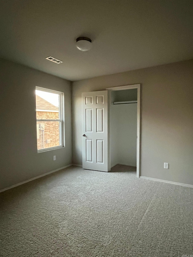 unfurnished bedroom featuring carpet and a closet