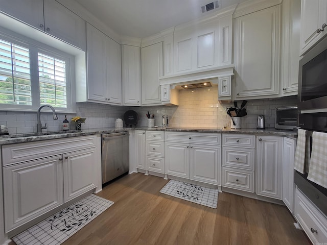 6413 Ram Rd, Mabelvale, AR 72103 - kitchen featuring stainless steel appliances, dark wood-style flooring, white cabinets, backsplash, and stone countertops