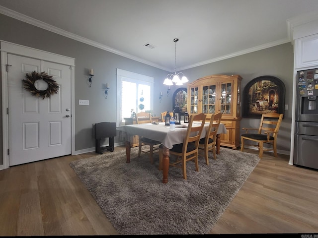 6413 Ram Rd, Mabelvale, AR 72103 - dining space with crown molding, wood finished floors, and a chandelier