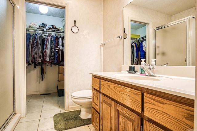 5 Lanza Ct, Hot Springs Village, AR 71909 - bathroom with vanity, a spacious closet, tile patterned flooring, a textured ceiling, and a stall shower