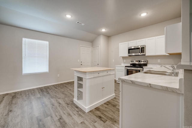 1375 Lacroix Ln, Conway, AR 72034 - kitchen featuring stainless steel appliances, a kitchen island, light wood finished floors, white cabinets, and open shelves