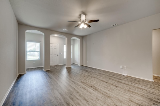 1375 Lacroix Ln, Conway, AR 72034 - empty room featuring arched walkways, ceiling fan, and wood finished floors