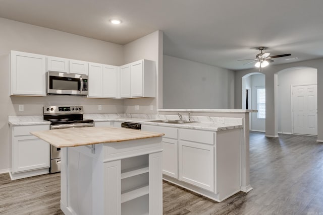 1375 Lacroix Ln, Conway, AR 72034 - kitchen with stainless steel appliances, butcher block counters, arched walkways, a peninsula, and a center island