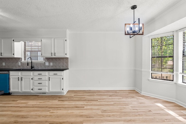 120 Whitewood Dr, Sherwood, AR 72120 - kitchen featuring dark countertops, a textured ceiling, healthy amount of natural light, crown molding, and white cabinets