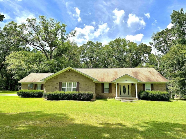 6823 Nevins Rd, Pine Bluff, AR 71603 - single story home with brick siding, a front lawn, and view of scattered trees