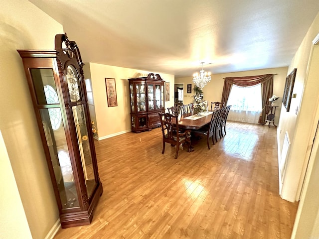 6823 Nevins Rd, Pine Bluff, AR 71603 - dining space featuring a chandelier and light wood-style flooring