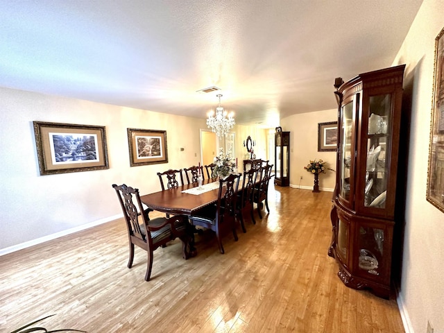 6823 Nevins Rd, Pine Bluff, AR 71603 - dining area featuring a chandelier and light wood-style flooring