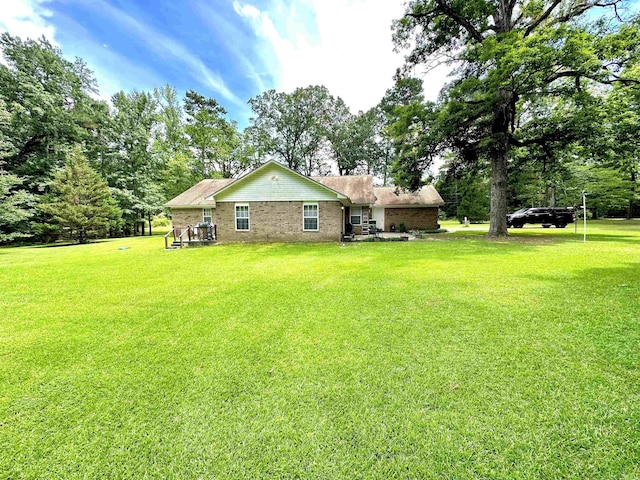 6823 Nevins Rd, Pine Bluff, AR 71603 - rear view of house with a lawn and view of wooded area