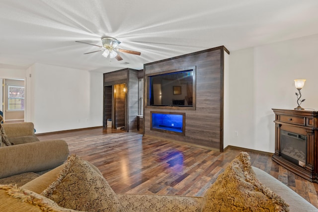 529 Charlie Stover, Royal, AR 71968 - living area with a glass covered fireplace, wood finished floors, and a ceiling fan