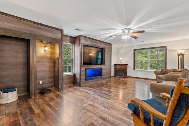 529 Charlie Stover, Royal, AR 71968 - living room with a fireplace, wood finished floors, a ceiling fan, and wood walls