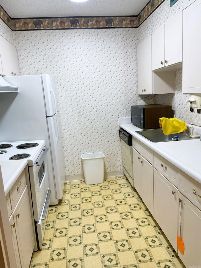 700 E 9th St Unit 6L, Little Rock, AR 72202 - kitchen with white appliances, wallpapered walls, light countertops, and white cabinetry