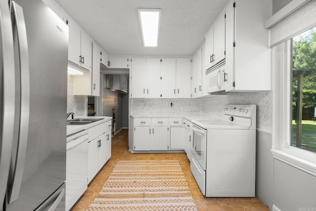 7616 Samples Rd, Benton, AR 72019 - kitchen with white appliances, light countertops, white cabinetry, and decorative backsplash