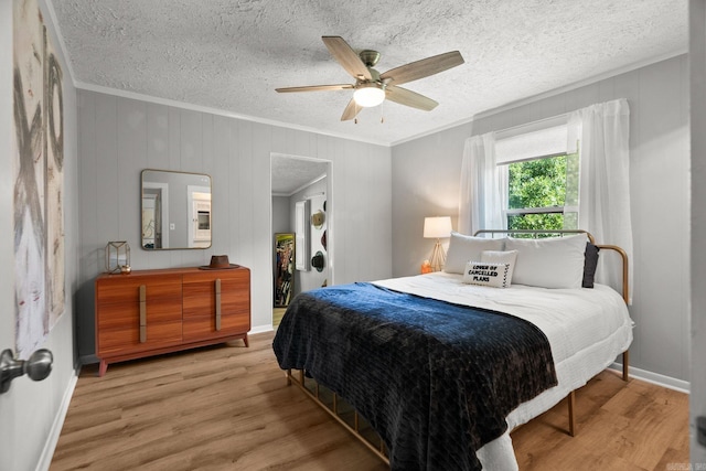 7616 Samples Rd, Benton, AR 72019 - bedroom featuring crown molding, light wood-style flooring, a ceiling fan, and a textured ceiling
