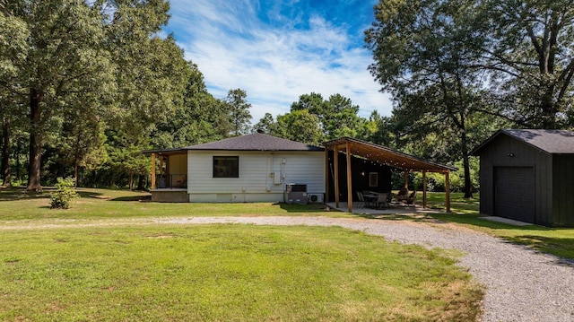7616 Samples Rd, Benton, AR 72019 - view of side of home featuring gravel driveway, a yard, an outdoor structure, a patio area, and a garage