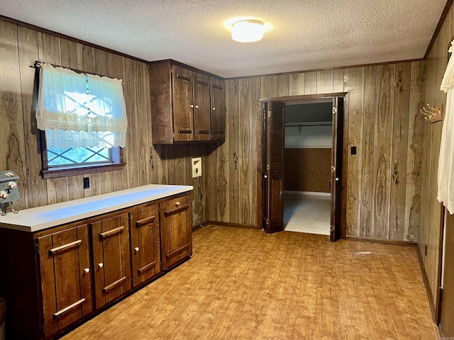 101 Fairway Dr, Bald Knob, AR 72010 - kitchen with a textured ceiling, wood walls, parquet floors, dark brown cabinetry, and light countertops