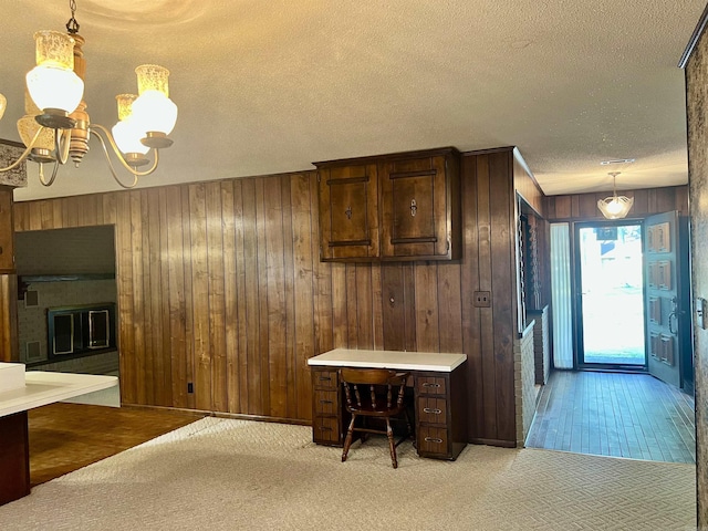 101 Fairway Dr, Bald Knob, AR 72010 - kitchen featuring wooden walls, a textured ceiling, dark brown cabinetry, a chandelier, and light countertops