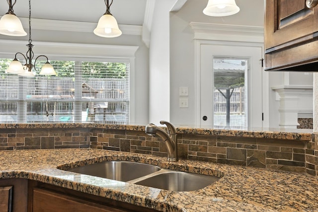 6137 Remington Dr, Bryant, AR 72022 - kitchen view of dark stone counters, decorative backsplash, crown molding, and pendant lighting