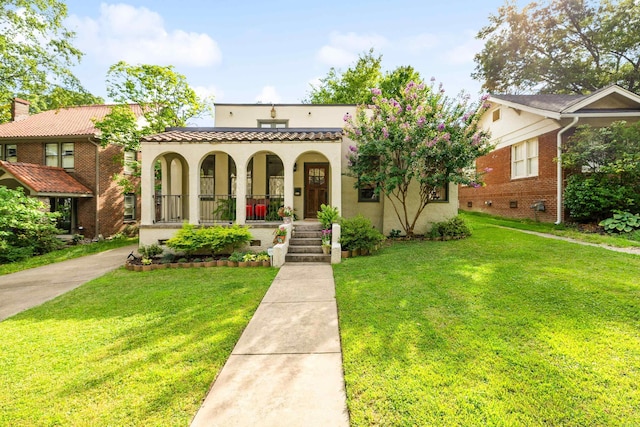 120 Crystal Ct, Little Rock, AR 72205 - mediterranean / spanish home with covered porch, a front yard, stucco siding, and brick siding