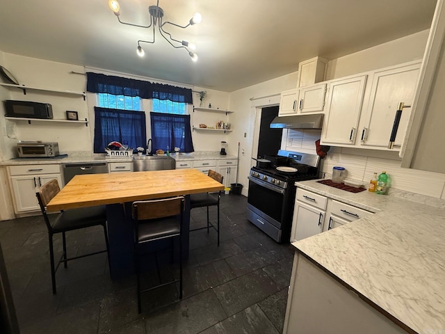 3000 S Cherry St, Pine Bluff, AR 71603 - kitchen with stainless steel range with gas cooktop, open shelves, under cabinet range hood, and white cabinets