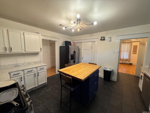 3000 S Cherry St, Pine Bluff, AR 71603 - kitchen featuring stainless steel appliances, butcher block counters, white cabinetry, a chandelier, and dark tile patterned flooring