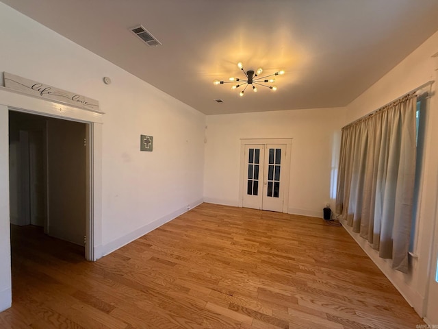 3000 S Cherry St, Pine Bluff, AR 71603 - spare room featuring light wood-style floors, a chandelier, and french doors
