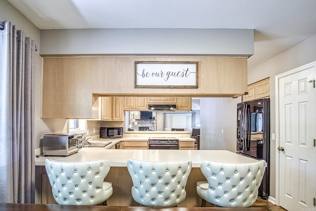 23 Emanuel Dr, Hot Springs Village, AR 71909 - kitchen featuring black appliances, light countertops, light brown cabinets, a peninsula, and a kitchen bar