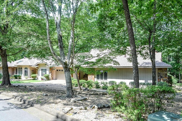 23 Emanuel Dr, Hot Springs Village, AR 71909 - view of front facade with a garage, a chimney, concrete driveway, and stone siding