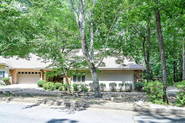 23 Emanuel Dr, Hot Springs Village, AR 71909 - view of front facade with a garage, driveway, a shingled roof, and stone siding