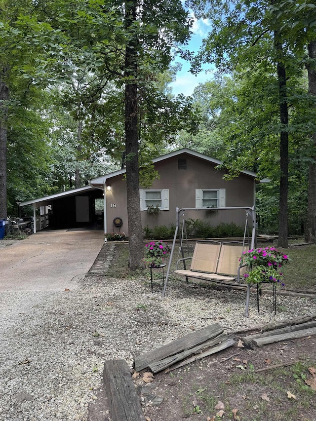 view of front of property featuring concrete driveway, a carport, and stucco siding