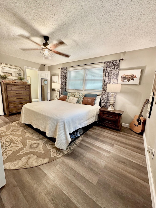 bedroom with wood finished floors, a textured ceiling, and a ceiling fan