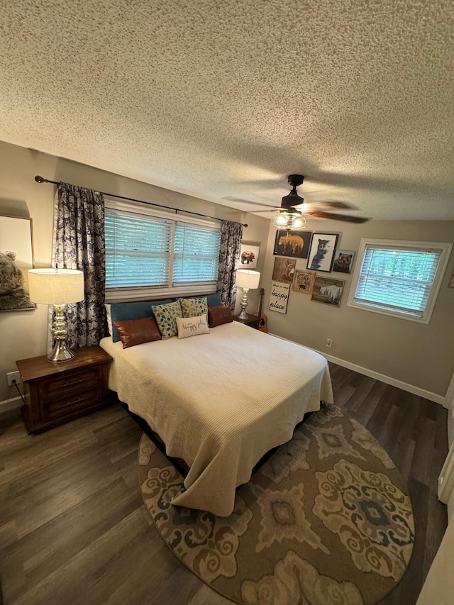 bedroom featuring dark wood-style floors, a textured ceiling, and ceiling fan