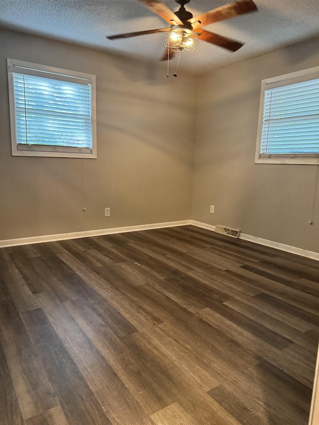 spare room featuring a ceiling fan, dark wood-style floors, and a textured ceiling