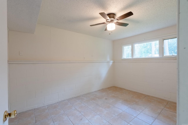 2128 Yamania Way, Heber Springs, AR 72543 - empty room featuring a textured ceiling, a ceiling fan, a wainscoted wall, and light tile patterned flooring