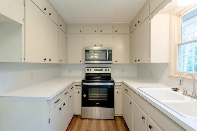 2128 Yamania Way, Heber Springs, AR 72543 - kitchen featuring appliances with stainless steel finishes, light wood-style flooring, white cabinets, and light countertops