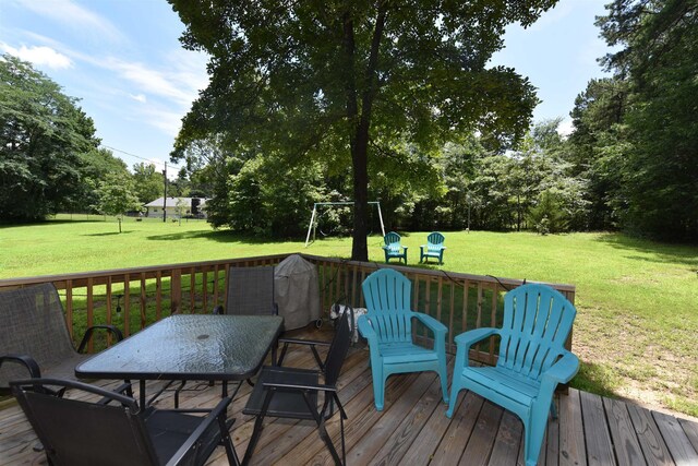 242 Lakeview Dr, Fairfield Bay, AR 72088 - wooden deck featuring a lawn, outdoor dining area, and view of wooded area