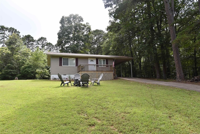 242 Lakeview Dr, Fairfield Bay, AR 72088 - back of house with asphalt driveway, a yard, a wooden deck, a carport, and view of scattered trees