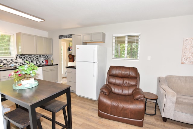 242 Lakeview Dr, Fairfield Bay, AR 72088 - kitchen featuring white appliances, gray cabinets, dark countertops, light wood-style floors, and decorative backsplash