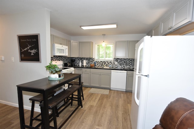 242 Lakeview Dr, Fairfield Bay, AR 72088 - kitchen with white appliances, light wood-style floors, backsplash, dark countertops, and gray cabinetry