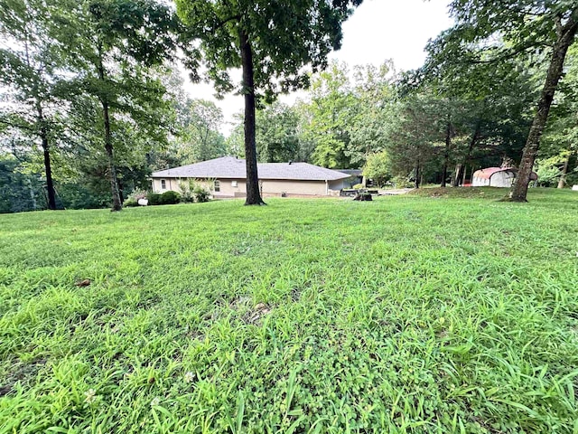 67 Powhatan Dr, Cherokee Village, AR 72529 - view of green lawn featuring view of scattered trees and a shed