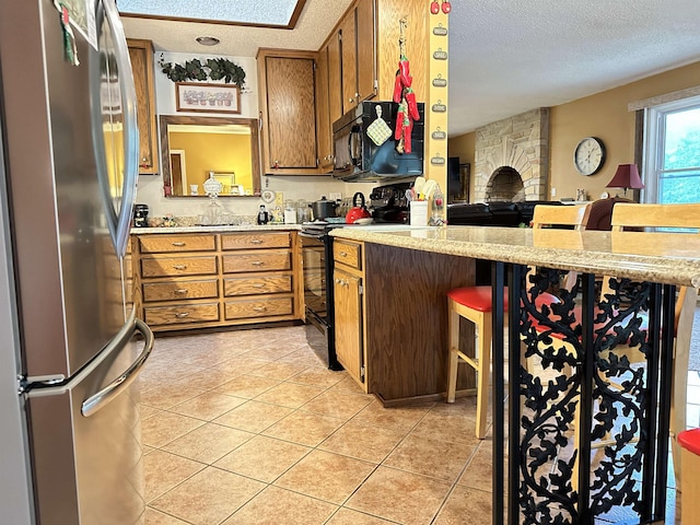 67 Powhatan Dr, Cherokee Village, AR 72529 - kitchen featuring black appliances, a textured ceiling, light countertops, and a peninsula