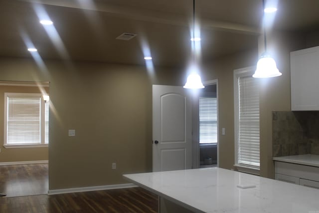 1300 W 28th Ave, Pine Bluff, AR 71603 - kitchen with white cabinets, dark wood-type flooring, light stone countertops, decorative backsplash, and decorative light fixtures