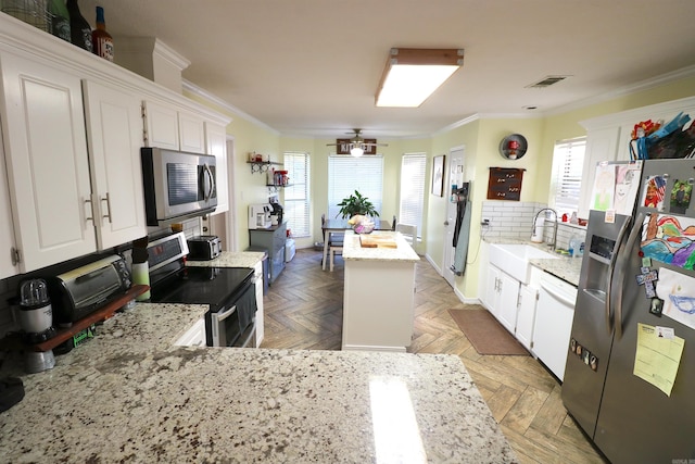 34 Ridge Rd, Cabot, AR 72023 - kitchen featuring appliances with stainless steel finishes, crown molding, healthy amount of natural light, white cabinetry, and a ceiling fan