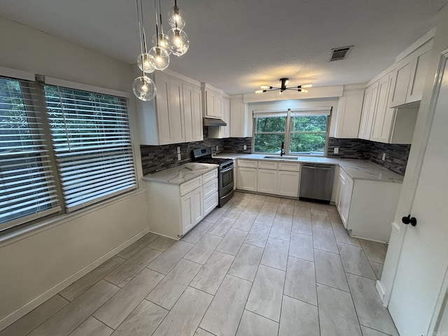 11220 Bainbridge Dr, Little Rock, AR 72212 - kitchen with appliances with stainless steel finishes, under cabinet range hood, tasteful backsplash, and white cabinets