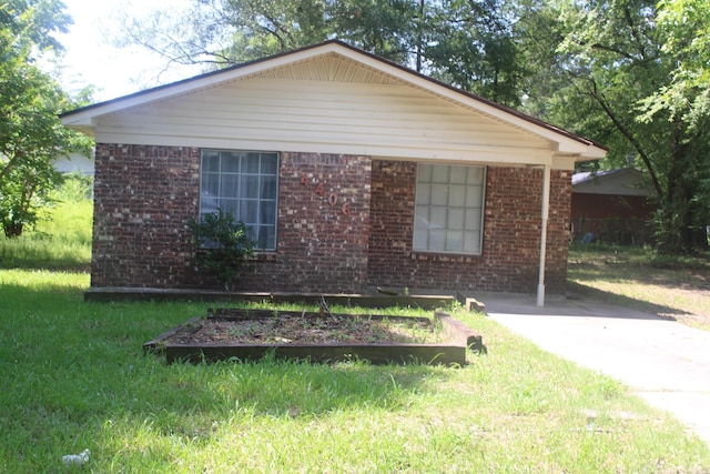4406 W 16th Ave, Pine Bluff, AR 71603 - view of front of house featuring a vegetable garden, brick siding, and a front yard